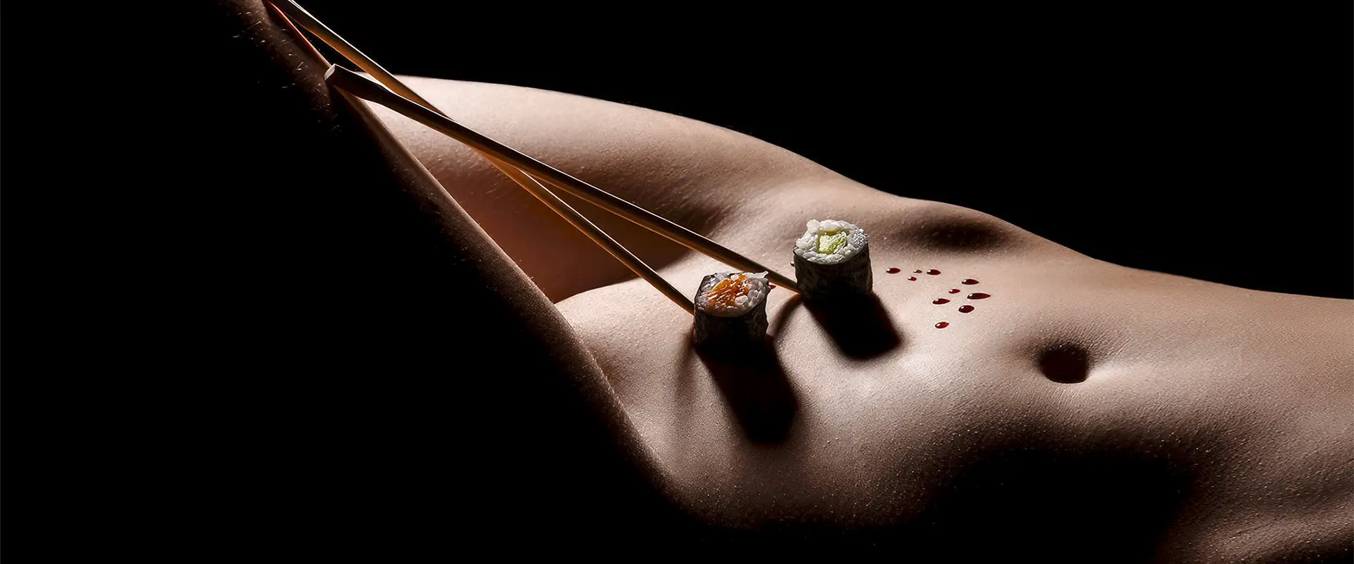 Sushi und Essstäbchen auf dem Bauch. Kunstvolles Dessous-Aktfotoshooting in Karlsruhe